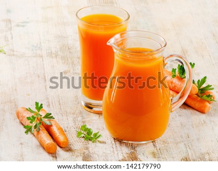 Carrot juice  and carrots on a wooden table. Selective focus