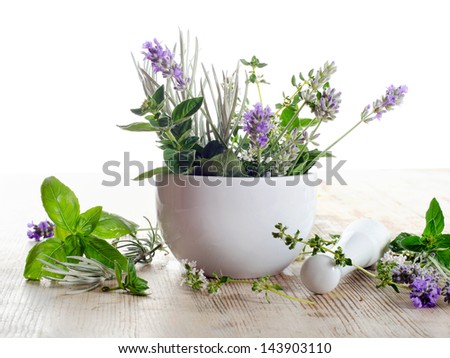 Fresh herbs on a wooden table isolated on white