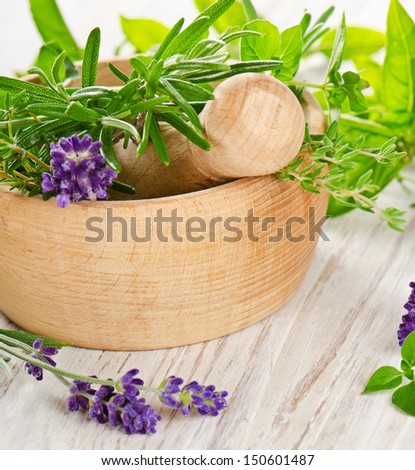 Fresh herbs in a wooden mortar. Selective focus