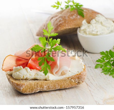 Baguette with bacon and cream cheese with herbs. Selective focus