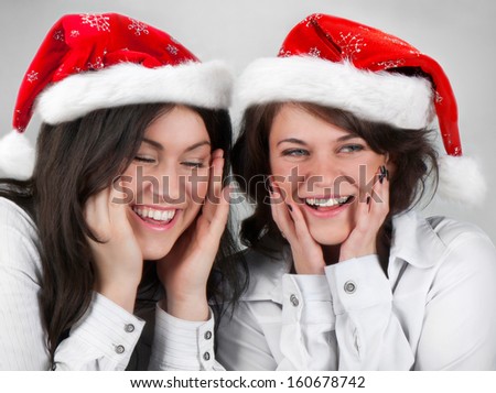 Two young happy smiling girls in Santa hats
