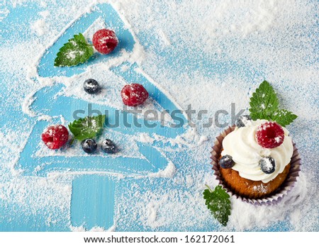 Cupcakes and sweet christmas decorations with fresh berries
