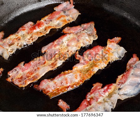 Cooked bacon rashers on a skillet. Selective focus