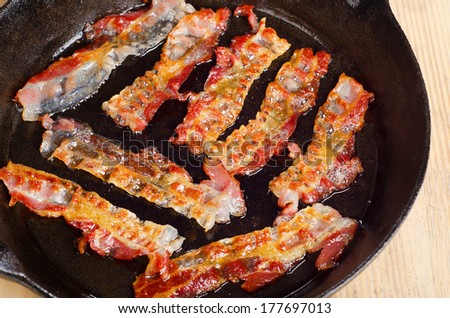 Cooked bacon rashers on a skillet. Selective focus