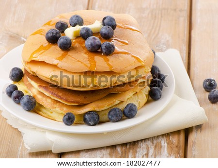 Pancakes topped with honey and berries . Selective focus