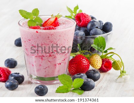 Berry smoothie with fresh berries on a wooden table . Selective focus