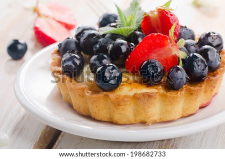 Fresh berries tart on a white plate. Selective focus