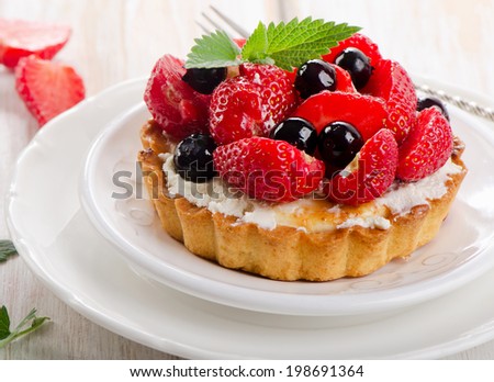 Fresh berries tart on a white plate. Selective focus