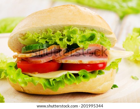 Fresh sandwich  on a wooden cutting board. Selective focus
