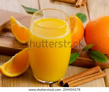 Glass of  orange juice with sliced orange  on wooden table. Selective focus