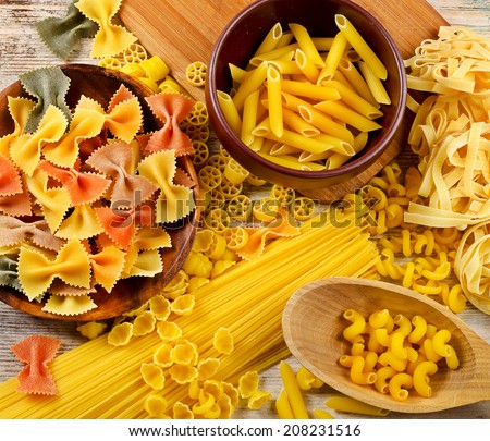 Uncooked italian pasta on a wooden table