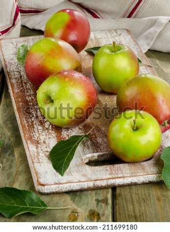 Apples with water drops on a wooden table.