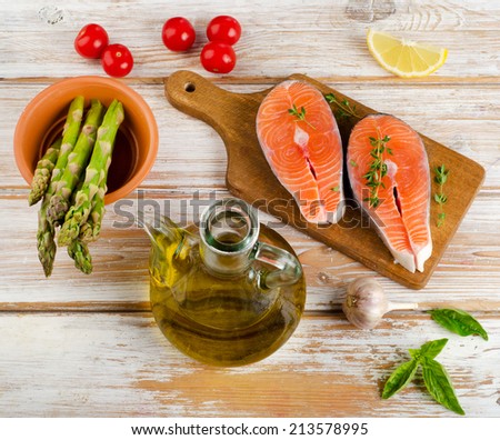 Healthy food  ingredients - salmon,asparagus and olive oil on  wooden table.