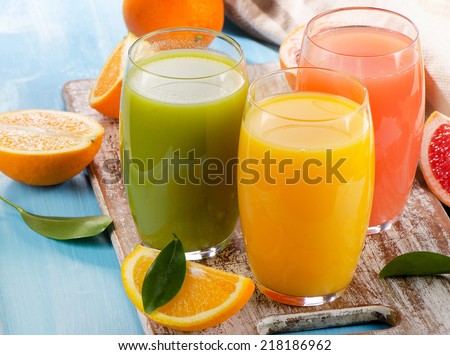 Citrus juice and fruits  on wooden background. Selective focus