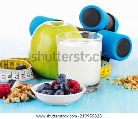 dumbbells with  healthy food and drink on  blue bakground. Selective focus
