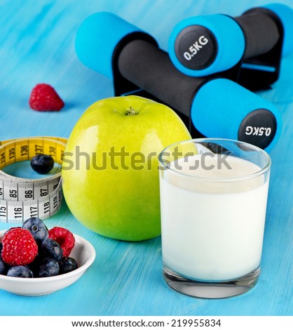 dumbbells with  healthy food and drink on a blue bakground. Selective focus