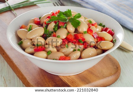Salad with white beans on a wooden table. Selective focus