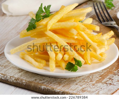French fries on  wooden board. Selective focus
