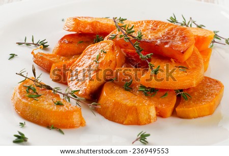 Baked sweet potato wedges on  white plate. Selective focus