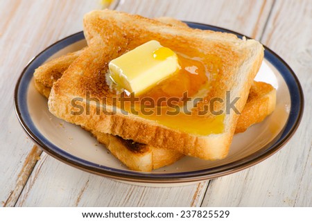 Slices toast bread with butter on a wooden background .