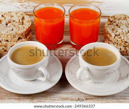 Healthy breakfast with  two coffee cup, orange juice and toast on a white wood table.