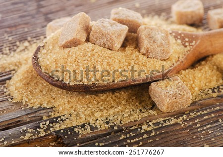 Brown cane sugar in a wooden spoon. Selective focus