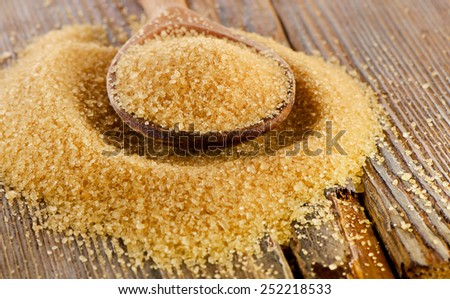 Brown Cane Sugar in  a wooden spoon. Selective focus