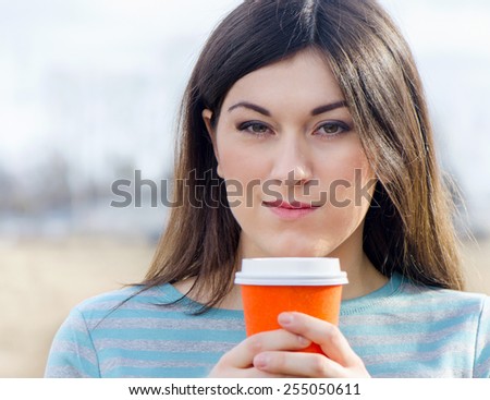 Woman with Coffee in To-Go Cup outdoors. Selective focus
