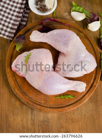 Fresh raw chicken legs on a kitchen cutting board. Top view