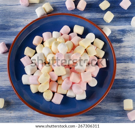 Colorful small marshmallows on a blue background.