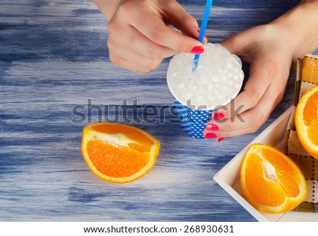 Woman hand holding a cup of fresh milk . Top view