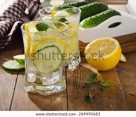 Fresh water with lemon, mint  and cucumber  on  wooden background. Selective focus