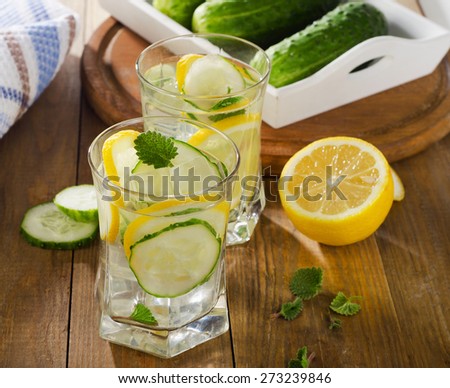 Water with lemon, mint  and cucumber  on  wooden background. Selective focus