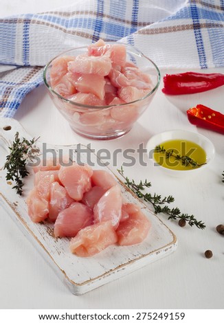 Chicken meat with herbs and olive oil on  a wooden cutting board. Selective focus