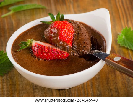 Homemade Chocolate Mousse with fresh berries on a old rustic    wooden table. Selective focus