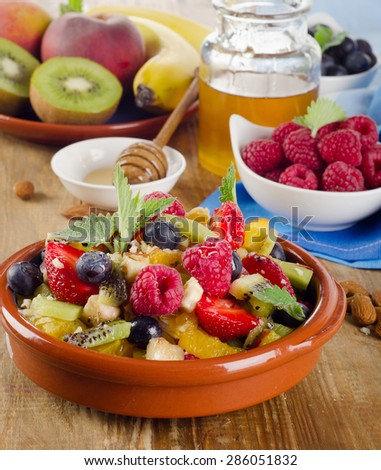 Healthy homemade fruit salad, fresh berries and fruits on a  old wooden table. Top view