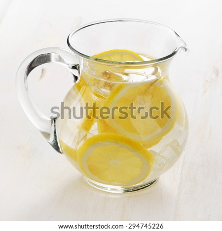 Water with lemon in glass jug. Selective focus