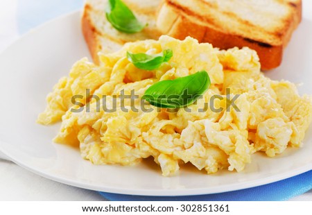 Scrambled eggs with fresh basil. Selective focus
