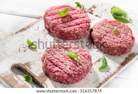 Raw Ground beef Burger steak patties on a wooden cutting board. Top view