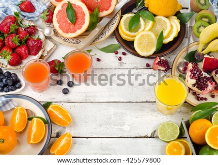 Citrus juice, fresh fruits and berries on white wooden background. Healthy eating, dieting. Top view