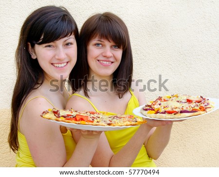 Two young happy women with pizza