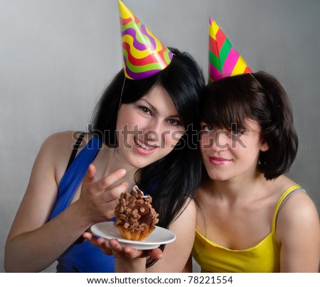 Two happy young women with cake