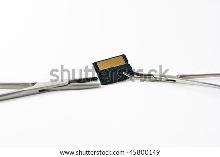 Two surgical clamps and a memory card over white background
