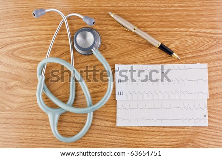 Wood texture background with stethoscope or phonendoscope ECG electrocardiogram graph and elegant pen