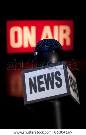 A Microphone with the word News on the side and on-air radio and television broadcast sign in the background with copy space. Vertical image.