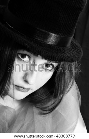 black and white image of a beautiful young woman in a hat