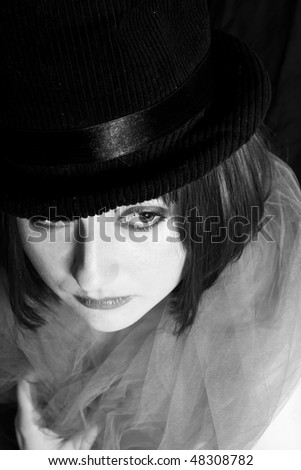 black and white image of a beautiful young woman in a hat