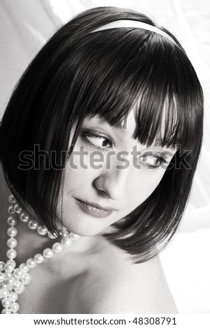 black and white image of a beautiful young woman with pearl beads