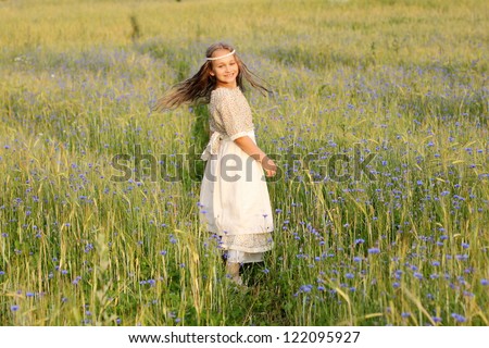 Calm and peaceful girl skips on a field of rye