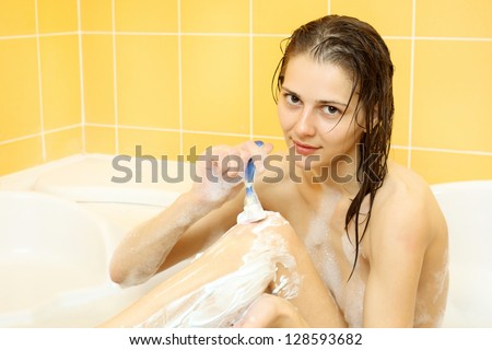 Nice simple naked girl shaves legs in bath